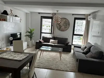 a living room with a couch and a table at Appartement Casa Finance City in Casablanca