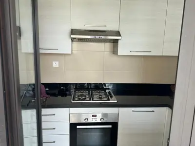 a kitchen with white cabinets and a stove top oven at Appartement Casa Finance City in Casablanca