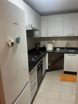a kitchen with white cabinets and a stove top oven at Appartement Casa Finance City in Casablanca