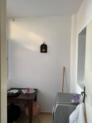 a room with a table and a clock on the wall at Garsoniere Borj in Rabat