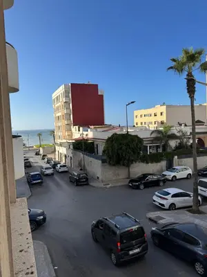 a parking lot with cars parked in front of a building at Garsoniere Borj in Rabat