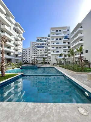 a swimming pool in front of some apartment buildings at Appartement a zenata ain-harrouda casablanca in Mohammedia