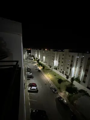 a view of a city street at night with cars parked at Séjour confortable, Plage Skhirat in Skhirat