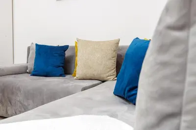 a couch with blue and yellow pillows on it at Luxury 1BR with Charming Balcony - Romantic Getaway in Rabat