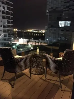 two chairs and a table on a balcony at night at Marina Ocean Suite - By Appart'Ayla in Casablanca