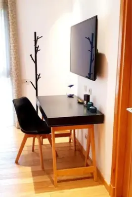 a table with a chair and a television on a wall at Marina Ocean Suite - By Appart'Ayla in Casablanca