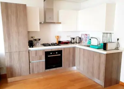 a kitchen with white cabinets and a stove top oven at Marina Ocean Suite - By Appart'Ayla in Casablanca