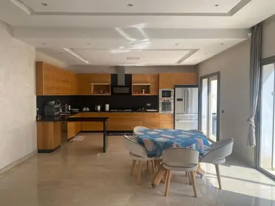 a kitchen and dining room with a table and chairs at Villa avec piscine Mohammedia in Mohammedia