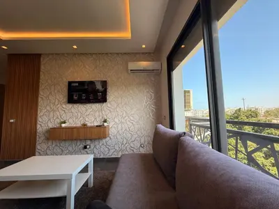 a living room with a couch and a table at Luxury studio center Abdelmoumen 1min tram with view in Casablanca