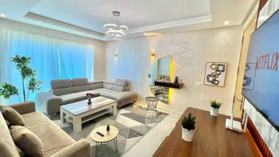 a living room with a couch and a table at Prestigia Hay Riad, Appartement Moderne au Style Chic in Rabat