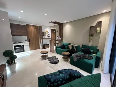 a living room with green couches and a kitchen at Studio4 Comfortable rest in Casablanca