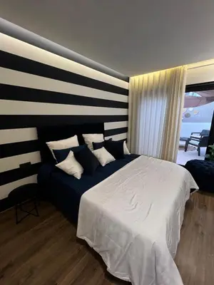 a bedroom with a large bed and a striped wall at Studio4 Comfortable rest in Casablanca