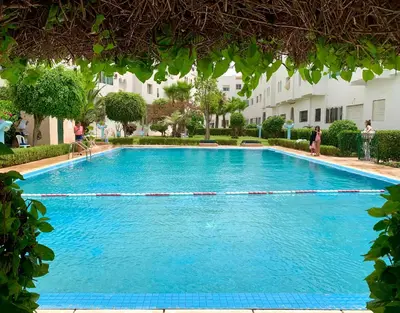 a large blue swimming pool in front of a building at Paradis Avec Piscine et Vue sur mer Harhoura in Temara