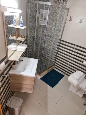 a bathroom with a shower and a sink at Grand appartement vue sur piscine Bouznika in Kasba Bou Hamira