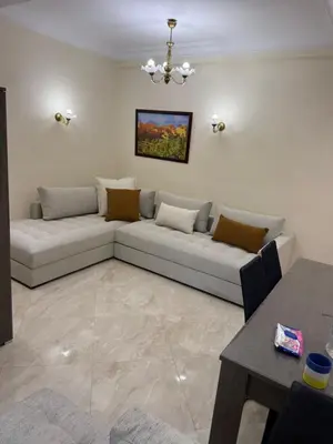 a living room with a couch and a table at Logement paisible in Bouznika