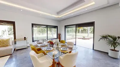 a dining room with a glass table and chairs at Villa S- Luxurious 8 masterbedrooms villa on 3000m2, close to all amenities, Golf and heart of Souissi in Rabat