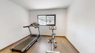 a fitness room with a treadmill and a window at Villa S- Luxurious 8 masterbedrooms villa on 3000m2, close to all amenities, Golf and heart of Souissi in Rabat