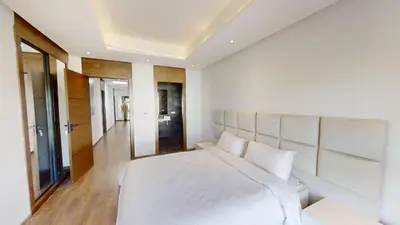 a white bedroom with a large bed and a hallway at Villa S- Luxurious 8 masterbedrooms villa on 3000m2, close to all amenities, Golf and heart of Souissi in Rabat