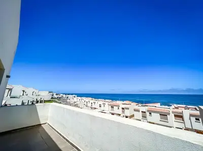 a view of the ocean from the balcony of a building at Villa de luxe résidence front de mer 50m de la mer in Tamaris