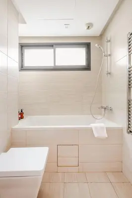 a white bathroom with a tub and a window at Sojori CFC fibre et parking in Casablanca
