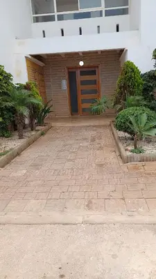 a house with a brick driveway and a wooden door at Sweet home in Dar Bouazza