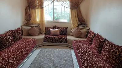 a living room with red couches and a window at Sweet home in Dar Bouazza