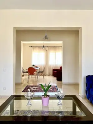 a living room with a table and a dining room at Appartement en résidence privée in Casablanca