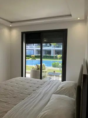 a bedroom with a bed and a view of a pool at Moroccan Beach Delight in Dar Bouazza