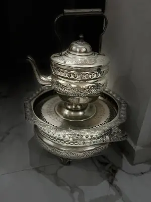 a silver tea pot on a plate on a table at Charm and Calm - Superbe appartement de luxe - Dahomy Beach - Bahia Beach in Bouznika