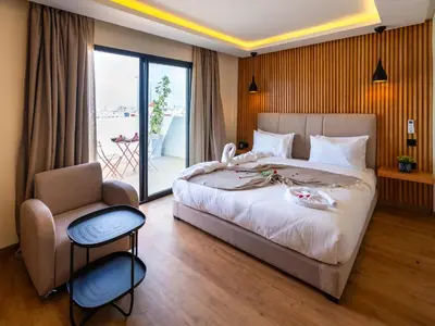 a bedroom with a bed and a chair and a window at Unico Hotel Maarif in Casablanca