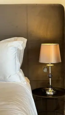 a lamp on a table next to a bed at Garden View and Terrace 3BR - AppartAli Luxury Platform in Casablanca