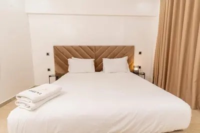 a large white bed with white sheets and pillows at Garden View and Terrace 3BR - AppartAli Luxury Platform in Casablanca