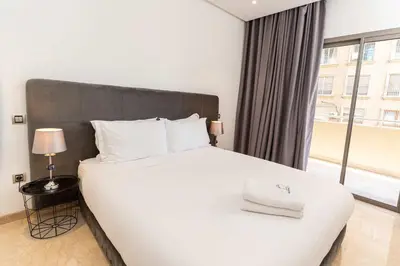 a bedroom with a white bed with a large window at 7th Floor 3BR with Terrace - AppartAli Luxury Platform in Casablanca