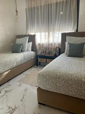 a bedroom with two beds and a window at Cosy appartement lumineux Awards 2026 in Bouznika