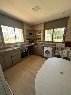 a kitchen with a table and a washing machine at Villa à Harhoura in Temara