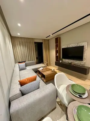 a living room with a couch and a tv at Studio Lilas CFC in Casablanca