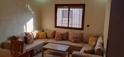 a living room with a couch and a window at Appartement très propre et calme in Bouznika