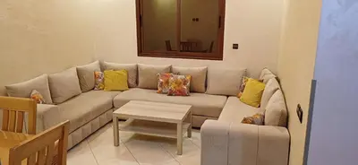 a living room with a couch and a table at Appartement très propre et calme in Bouznika