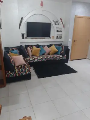 a couch with pillows sitting in a living room at Espace de détente in Bouznika