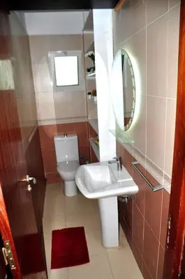 a bathroom with a toilet and a sink and a mirror at Appartement a louer Harhoura in Temara