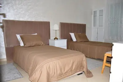 a bedroom with two beds and a couch in it at Appartement a louer Harhoura in Temara