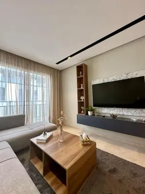 a living room with a couch and a large flat screen tv at Studio Jasmin CFC n 15 in Casablanca