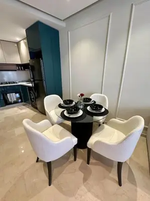 a dining room with a table and white chairs at Studio Vénus CFC n 22 in Casablanca