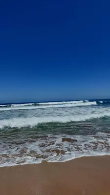 a view of the ocean with a beach with waves at Bel appartement de plage - RDC - Dahomey Beach in Bouznika