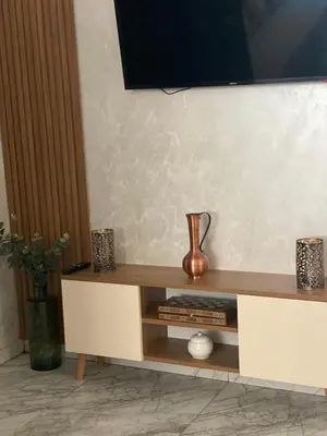 a entertainment center with a tv on top of it at Bel appartement de plage - RDC - Dahomey Beach in Bouznika