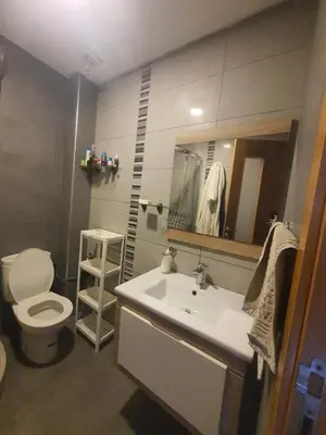 a bathroom with a sink and a toilet and a mirror at 2 bedroom appart at the beach in gated community with pool in Sidi Rahal