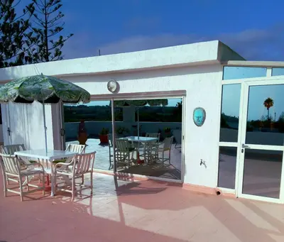 a patio with a table and chairs and an umbrella at Skhirat terrace apartment at the beach in Skhirat