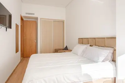 a bedroom with a large bed with white sheets at Studio Élégant avec piscine à Zenata Eco city in Aïn Harrouda
