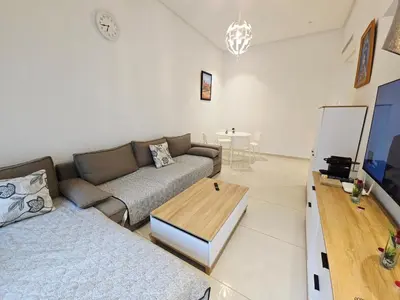 a living room with a couch and a table at Studio Élégant avec piscine à Zenata Eco city in Aïn Harrouda