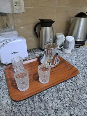 a wooden cutting board with two glasses and a tea kettle at très joli appartement vue sur mer présentation acte de mariage si couple in Rabat